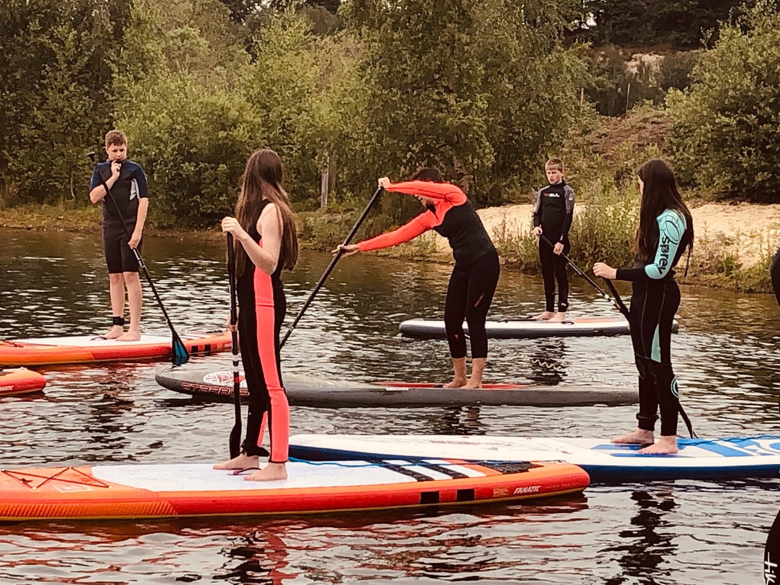 Paddlers practising paddle technique on flat inland water during a coached SUP session