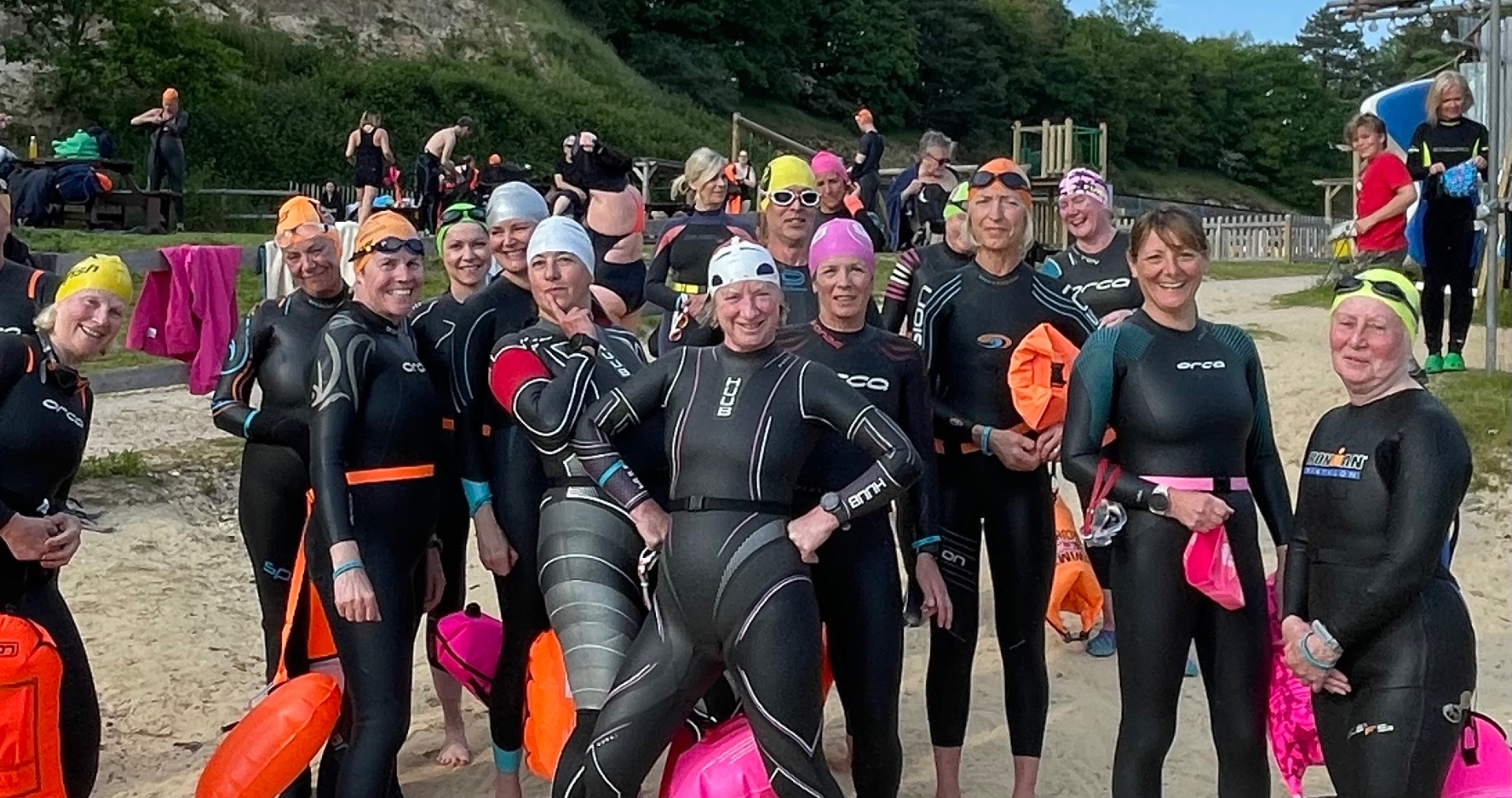 Group of participants in wetsuits preparing for a session
