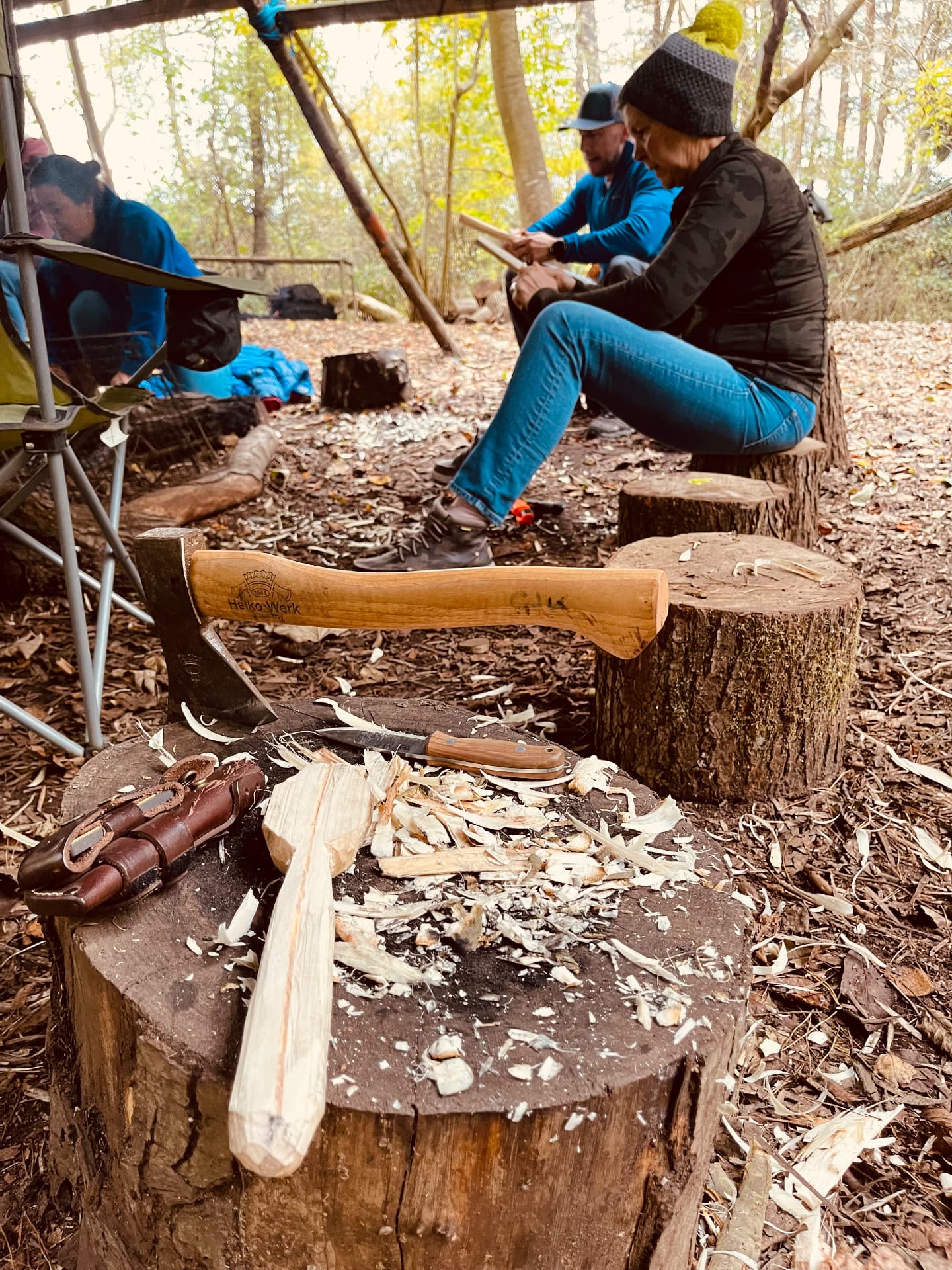 Spoon carving with axe and knife on a log at The SHAC Viking Camp at Buckland Park