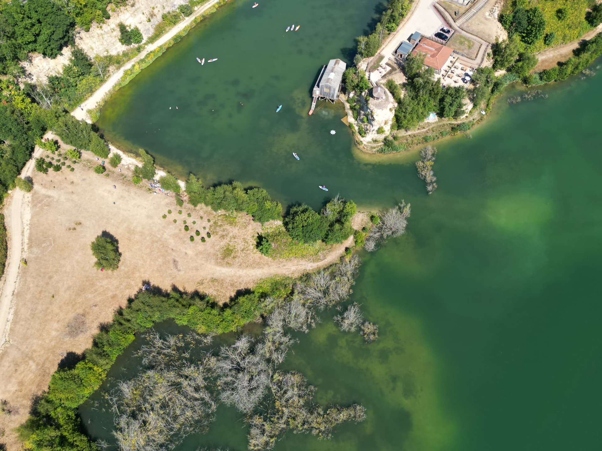 Aerial view of a developed outdoor activity venue — lake, boathouse, paths and lakeside buildings in use